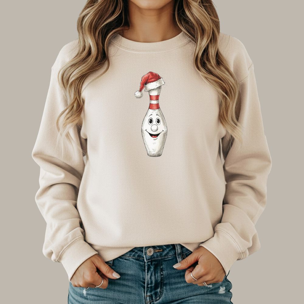 Beige sweatshirt with a cartoon bowling pin wearing a Santa hat on a plain background