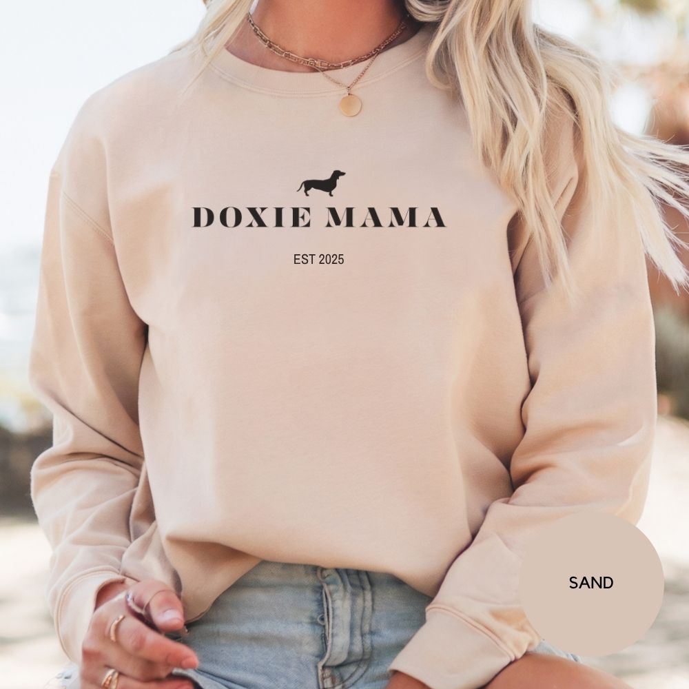 Woman wearing sand-colored Doxie Mama sweatshirt, cozy and stylish gift for dachshund lovers