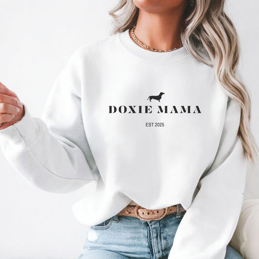Woman wearing white Doxie Mama crewneck sweatshirt with dachshund silhouette, perfect dog mom gift